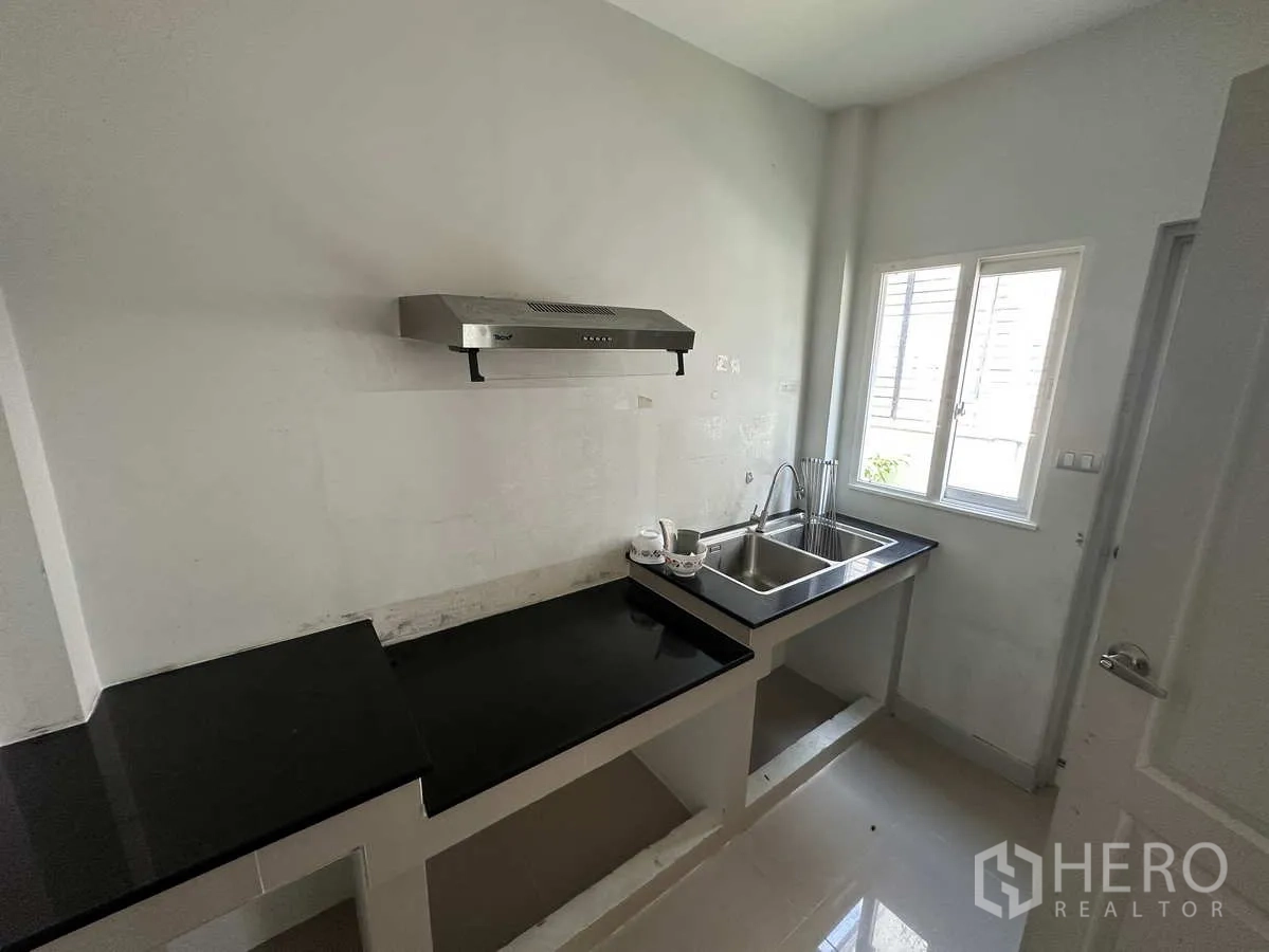 บ้าน ให้เช่าในKhlong Luang, Pathum Thani - ครัวไทยขนาดกะทัดรัด เคาน์เตอร์หินดำ อ่างล้าง และเครื่องดูดควัน