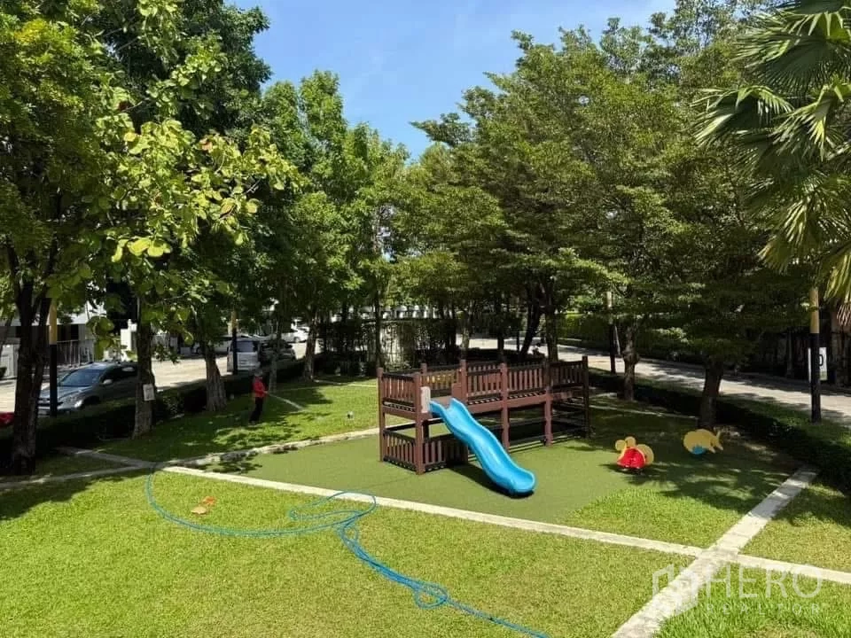 Detached House for rent or sale in Bueng Kum, Bangkok - Leafy community playground with slide and play equipment on artificial grass.