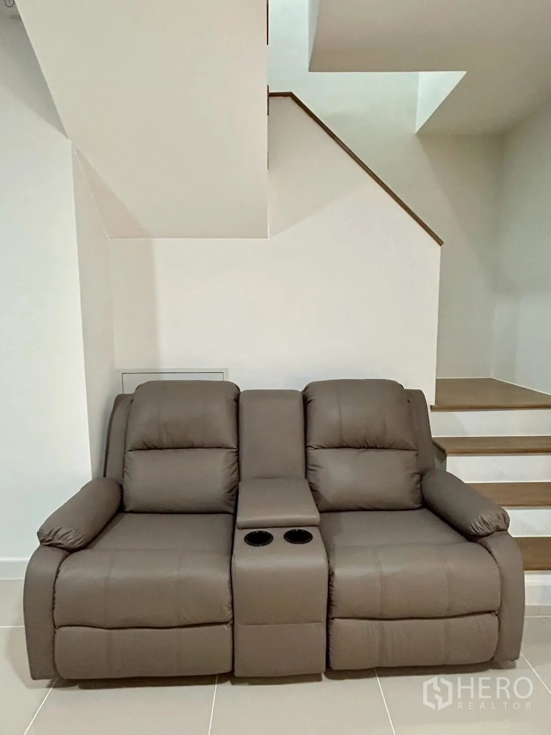 Townhouse for rent in Bang Phli, Samut Prakan - Reclining leather sofa beneath staircase in living area.