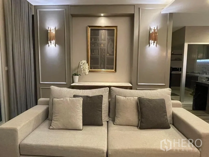 公寓 出售在Sathon, Bangkok - 中性色调的沙发区，配壁灯与装饰画，整体雅致。