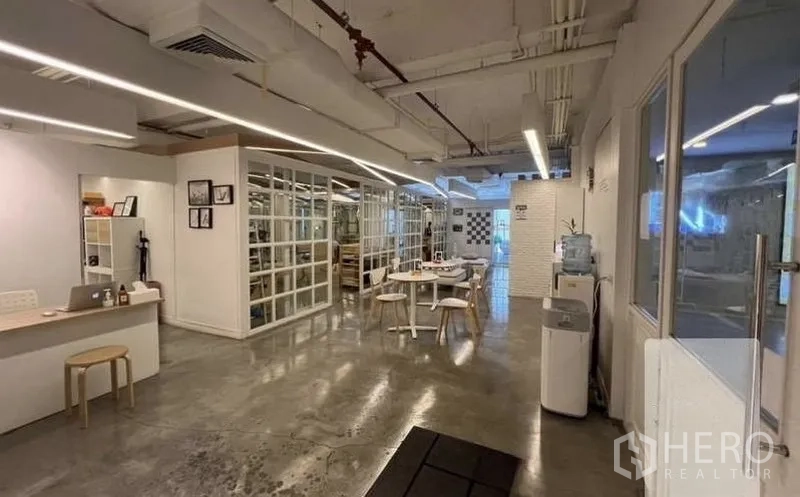 พื้นที่ขายปลีก ให้เช่า - โซนทำงานด้านหน้าของยูนิต เคาน์เตอร์ โต๊ะกลม และผนังกั้นกระจก