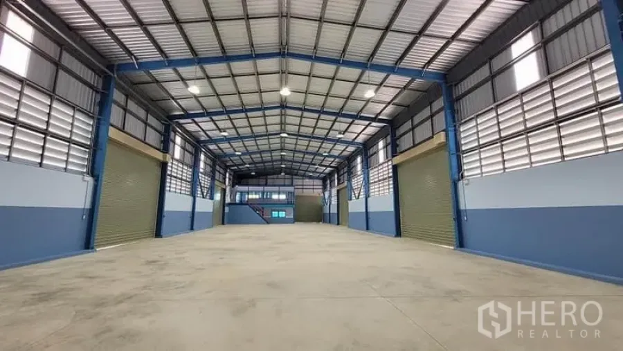 工厂 出租或出售在Phanat Nikhom, Chon Buri - 高挑屋顶的厂房内景，钢结构，照明明亮，设有多个卷帘门。