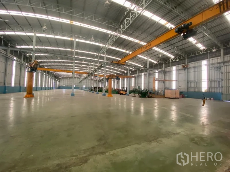 Factory for rent or sale in Samut Sakhon - Spacious production hall featuring several 5-ton bridge cranes and polished concrete floor.