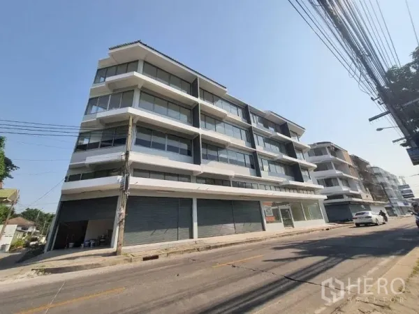 店屋 出售在Wang Thonglang, Bangkok - 曼谷旺通朗街道上的多层店屋外观，玻璃阳台与底层卷闸门临街。