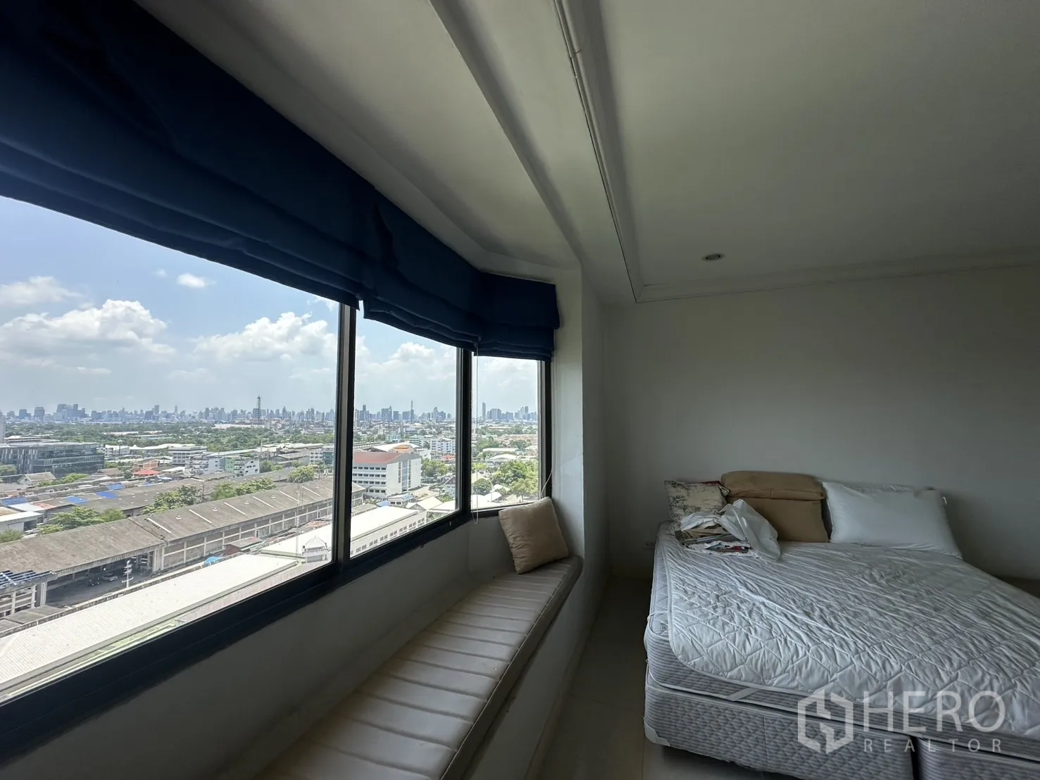 คอนโด ขายในBang Na, Bangkok - ห้องนอนมีเบย์วินโดว์พร้อมที่นั่งและวิวสกายไลน์ ข้างเตียง