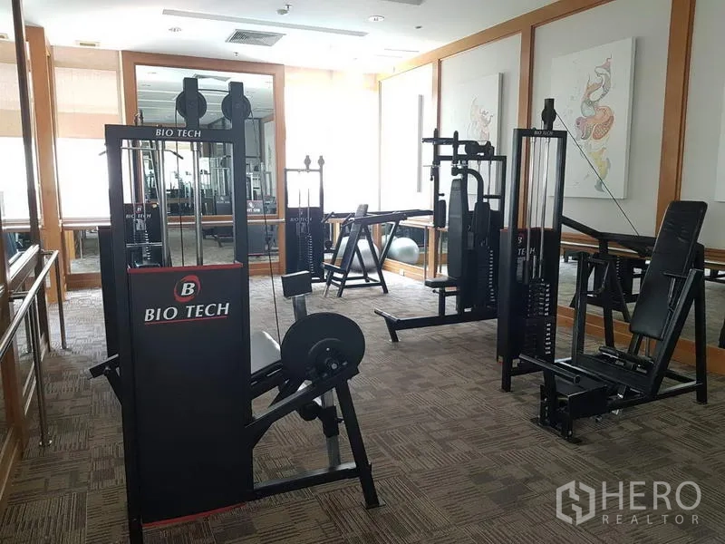 公寓 出租在Pathum Wan, Bangkok - 健身房配重量训练器械与镜面墙。