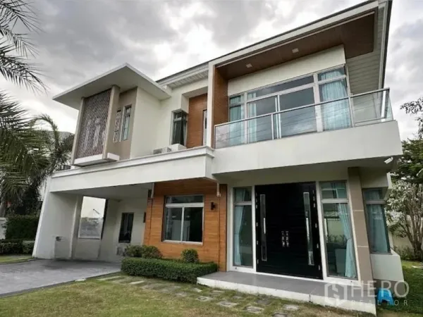 บ้าน ให้เช่าในLat Krabang, Bangkok - บ้านเดี่ยวสไตล์โมเดิร์น 2 ชั้น มีระเบียง กระจกบานกว้าง และประตูคู่ พร้อมสนามหญ้าตัดแต่ง บางพลี