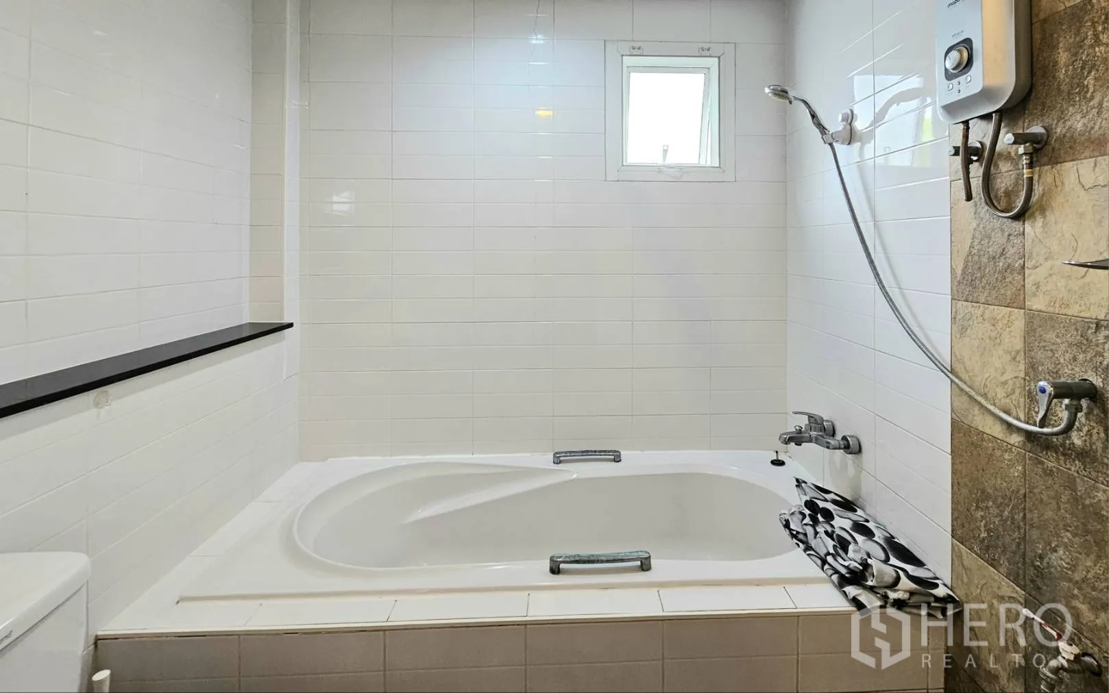 Detached House for rent in Saphan Sung, Bangkok - Bathroom with built-in bathtub, shower with water heater, and a small window.