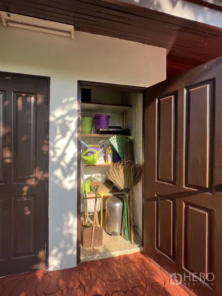 Detached House for rent in Bang Phli, Samut Prakan - Outdoor utility closet with shelves holding garden tools beside brown doors.
