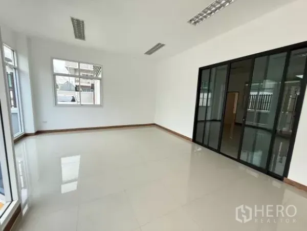 โรงงาน ขายในThanyaburi, Pathum Thani - ห้องสำนักงานชั้นล่างสว่าง โทนขาว พื้นกระเบื้อง ไฟฟลูออเรสเซนต์ และผนังกระจกกรอบอลูมิเนียมสีดำ