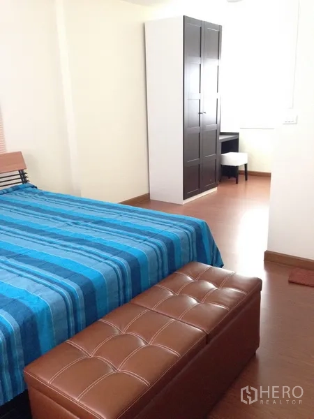 独立式住宅 出售在Phra Khanong, Bangkok - 第二卧室，蓝色床品、立式衣柜和软包长凳。