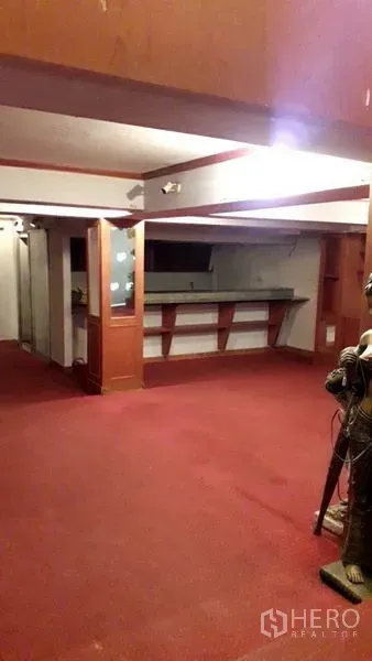 零售空间 出租在Watthana, Bangkok - 开放式零售楼层，红色地毯，木质装饰与服务吧台。