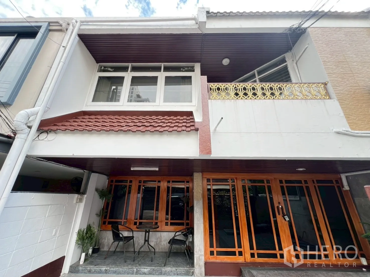 Home Office for rent in Watthana, Bangkok - Two-storey home office facade with balcony, white walls and wood-framed sliding doors.