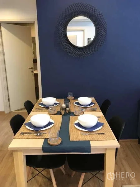 คอนโด ให้เช่าในWatthana, Bangkok - โต๊ะอาหารจัดเซ็ตสำหรับสี่ที่นั่ง ข้างผนังสีน้ำเงิน