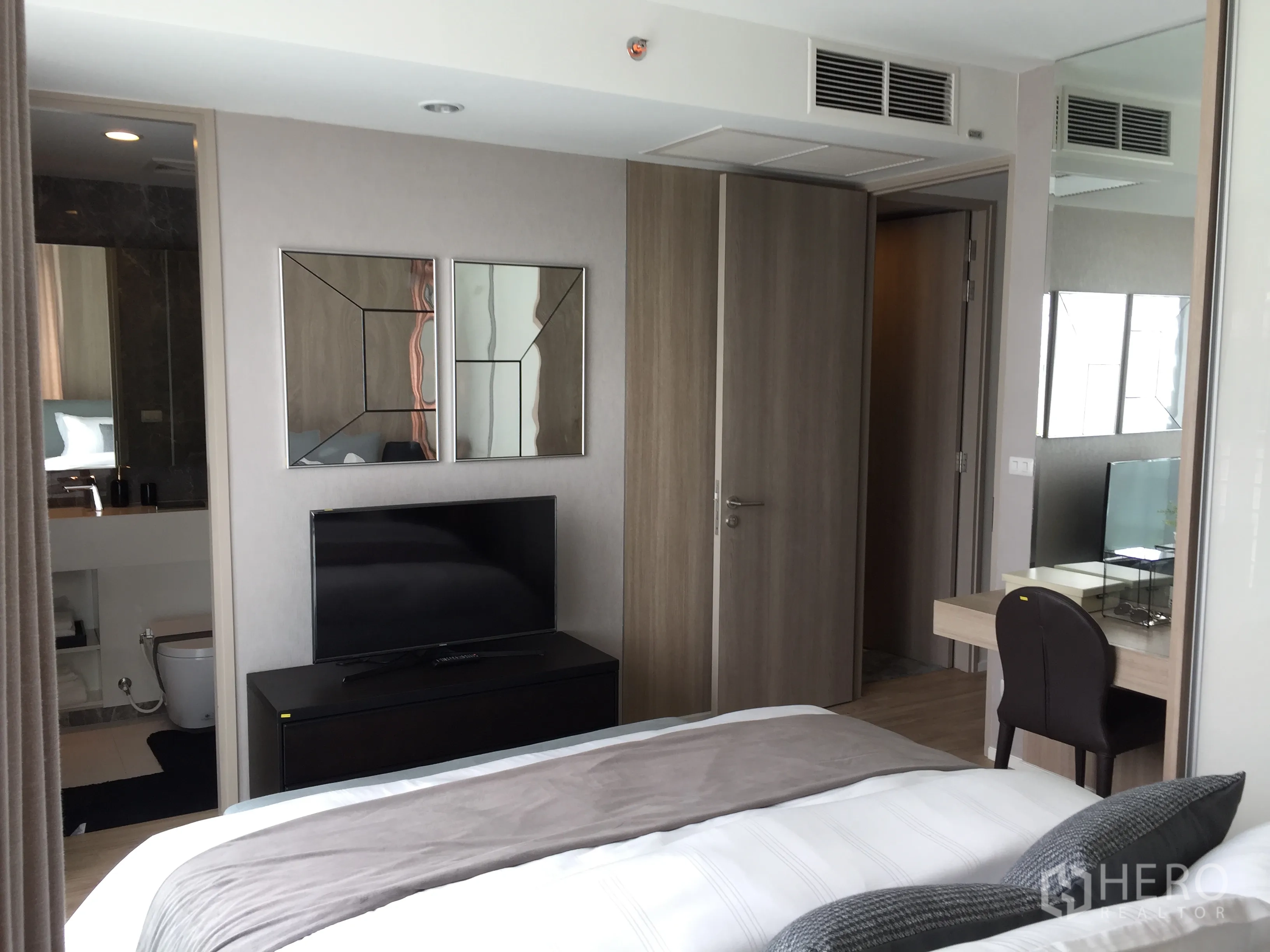 公寓 出售在Bang Rak, Bangkok - 卧室设电视柜与书桌，可见套内浴室入口