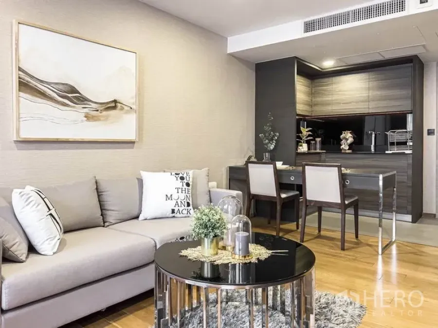 Condominium for rent in Pathum Wan, Bangkok - Living room and kitchenette layout with sectional sofa and dining set.