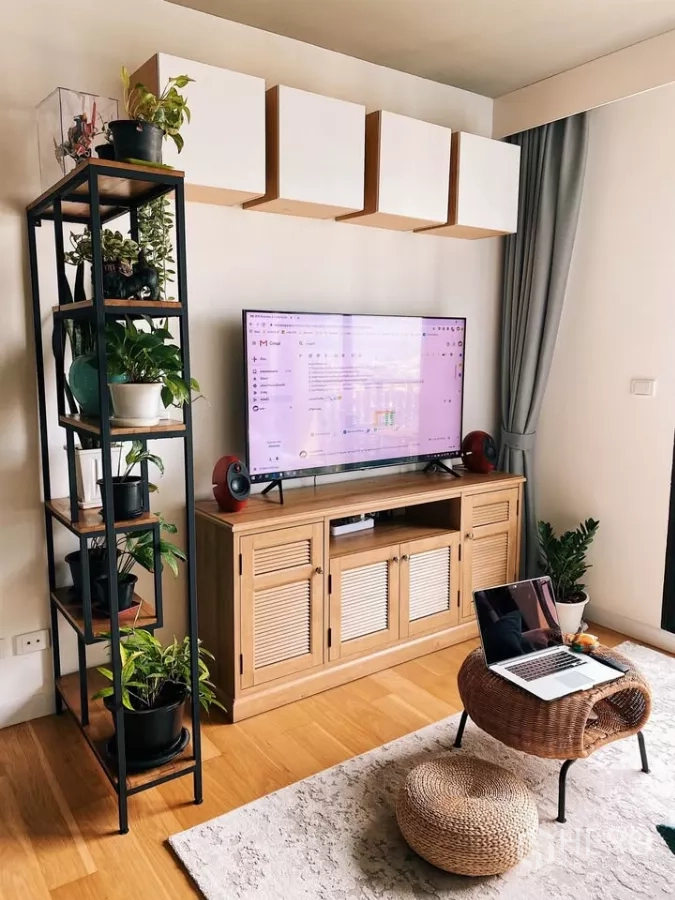 Condominium for rent in Watthana, Bangkok - Media console with overhead cabinets and plant shelf in a sunlit living room.
