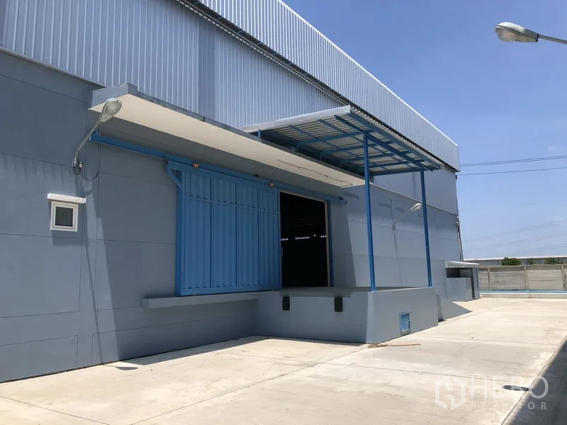 Warehouse for rent in Lat Lum Kaeo, Pathum Thani - Close-up of a raised loading bay with canopy and blue roller door suitable for truck docking.