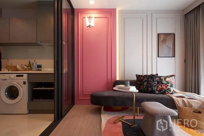 公寓 出售在Ratchathewi, Bangkok - 客厅带粉色特色墙，玻璃隔断开放式厨房与洗衣机。