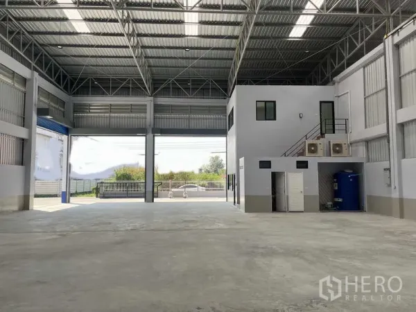 Warehouse for rent in Khlong Luang, Pathum Thani - Spacious warehouse interior with steel truss roof, skylights and a mezzanine office block.