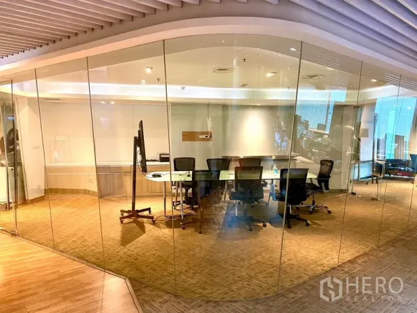 สำนักงาน ให้เช่าในWatthana, Bangkok - มุมมองกว้างของห้องประชุมใสและพื้นที่ทำงานแบบเปิด กั้นด้วยผนังกระจกเต็มสูงและไฟฝังเพดานโทนอุ่น