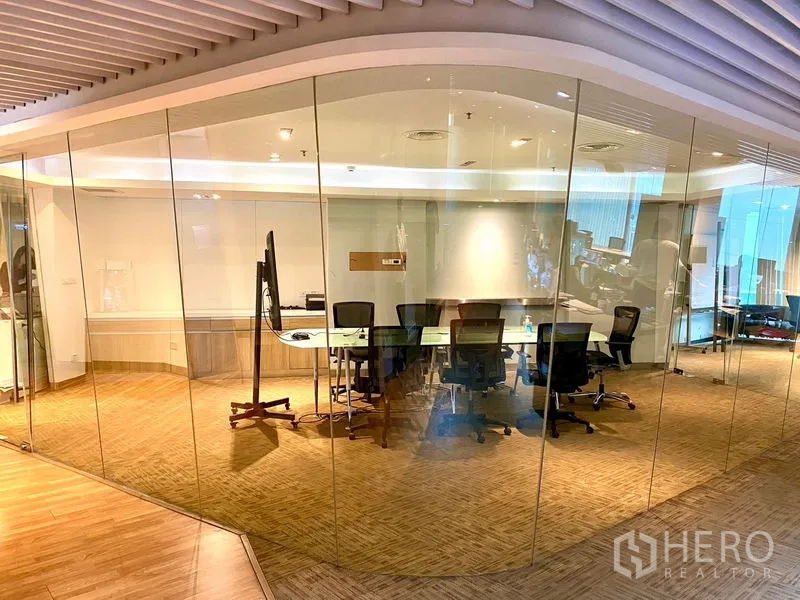 สำนักงาน ให้เช่าในWatthana, Bangkok - มุมมองกว้างของห้องประชุมใสและพื้นที่ทำงานแบบเปิด กั้นด้วยผนังกระจกเต็มสูงและไฟฝังเพดานโทนอุ่น
