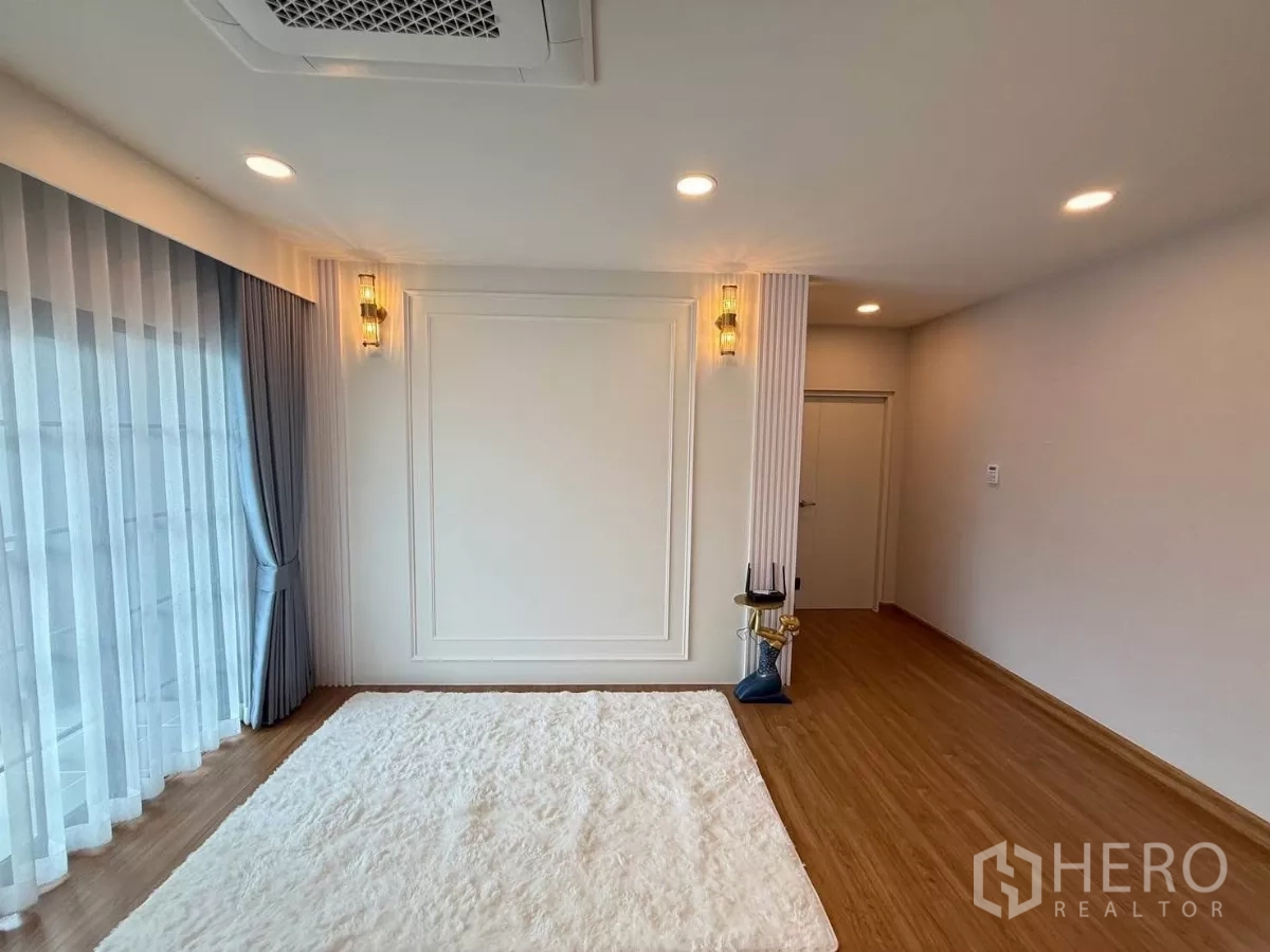 Detached House for rent in Bang Phli, Samut Prakan - Bright multipurpose room with large rug, wall sconces and full‑height curtains.