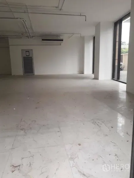 零售空间 出租在Watthana, Bangkok - 商铺单元配大理石纹地砖、侧窗与外露天花空调设备。