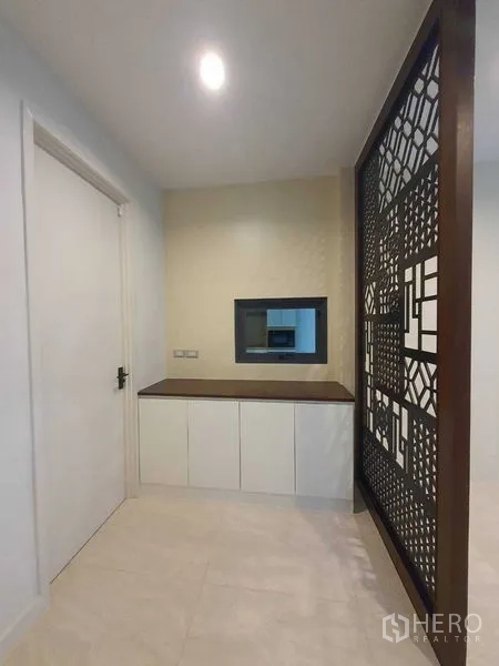 Detached House for sale in Prawet, Bangkok - Entry nook with storage cabinets and a decorative lattice partition.