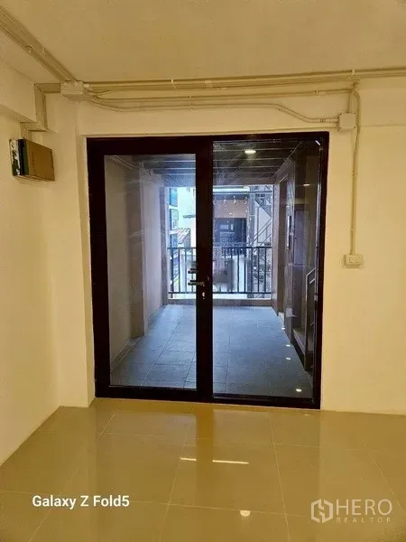 พื้นที่ขายปลีก ให้เช่า - มุมมองจากภายในไปยังประตูกระจกบานเลื่อนและระเบียงขนาดเล็กที่มองเห็นวิวถนน