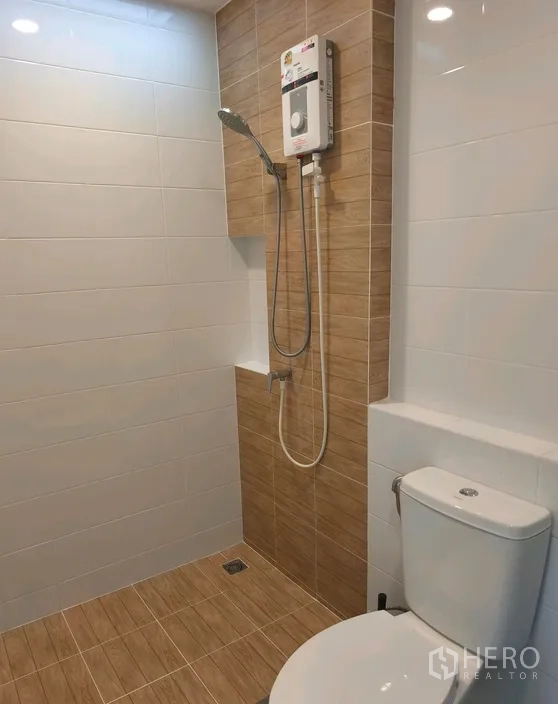 Townhouse for rent in Bang Phli, Samut Prakan - Bathroom featuring a shower water heater, tiled walls and toilet.