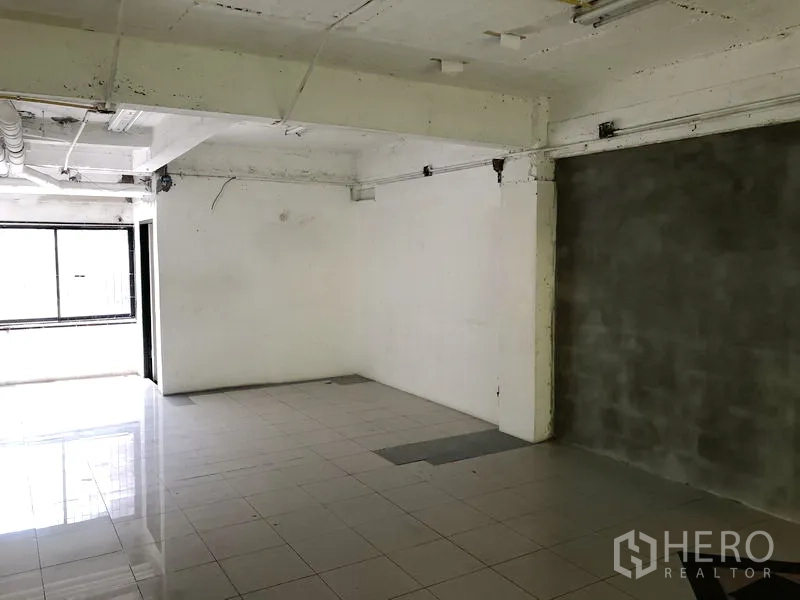 零售空间 出租在Khlong Toei, Bangkok - 开阔的零售区域，灰色特色墙、外露管线与大窗户。