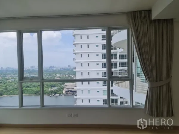 Condominium for sale in Yan Nawa, Bangkok - Corner windows showing greenery, river and a nearby high-rise from a high-floor condo.