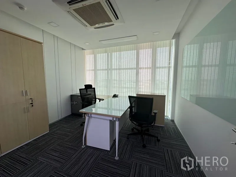 Office Space for rent - Private manager office with a glass whiteboard, storage cabinet and two desks.