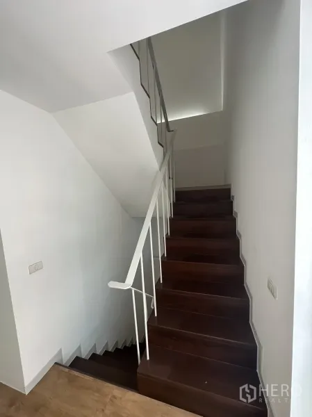 带办公室的家 出租在Phra Khanong, Bangkok - 楼梯间，深色木踏步和白色金属扶手。