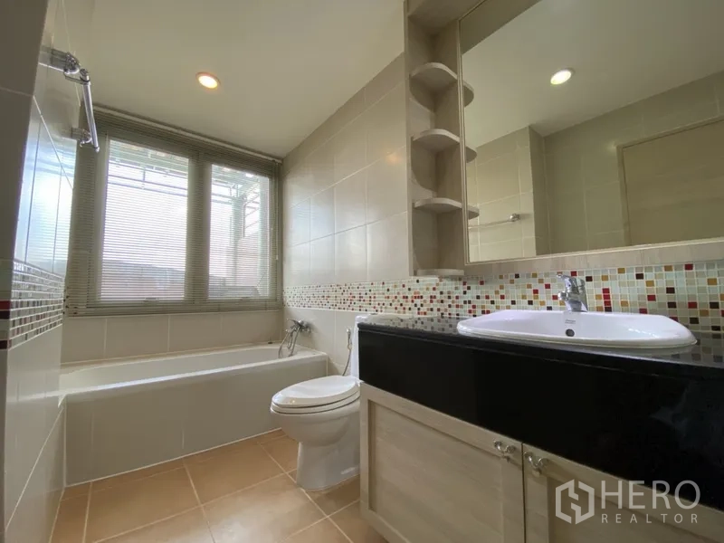 คอนโด ให้เช่าในBang Rak, Bangkok - ห้องน้ำสว่างพร้อมอ่างอาบน้ำ โมเสกตกแต่ง และเคาน์เตอร์อ่างล้างหน้า