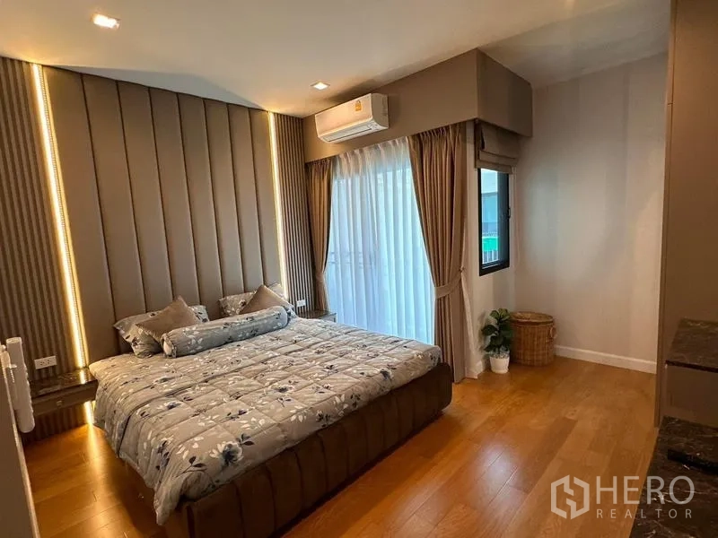 独立式住宅 出租在Prawet, Bangkok - 主卧暖色系，软包床头、窗帘与阳台落地门。