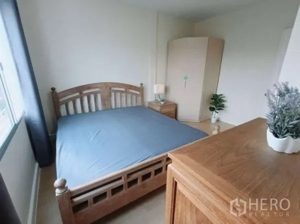 联排别墅 出租在Bang Kapi, Bangkok - 采光充足的卧室，木质床、斗柜、转角衣柜与窗帘。