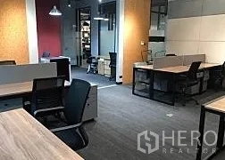 Office Space for rent in Khlong Toei, Bangkok - Open office layout with gray carpet, glass partitions, storage pedestals, and overhead lighting.