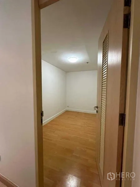 公寓 出售在Bang Rak, Bangkok - 空置的多功能小房，木地板与顶灯。