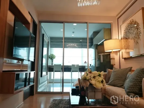 公寓 出租在Sathon, Bangkok - 客厅面向玻璃推拉门，通往采光充足的餐厨区和电视墙。