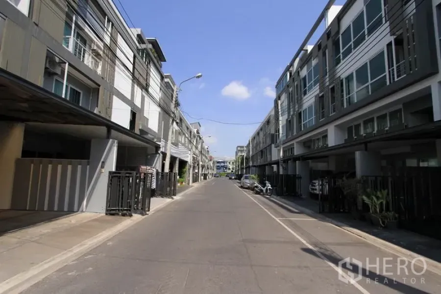 ทาวน์เฮาส์ ขายในWang Thonglang, Bangkok - ซอยที่อยู่อาศัยเงียบสงบ รายล้อมด้วยทาวน์เฮ้าส์สมัยใหม่หลายชั้นและที่จอดรถมีรั้ว ใต้ท้องฟ้าสีครามในวังทองหลาง