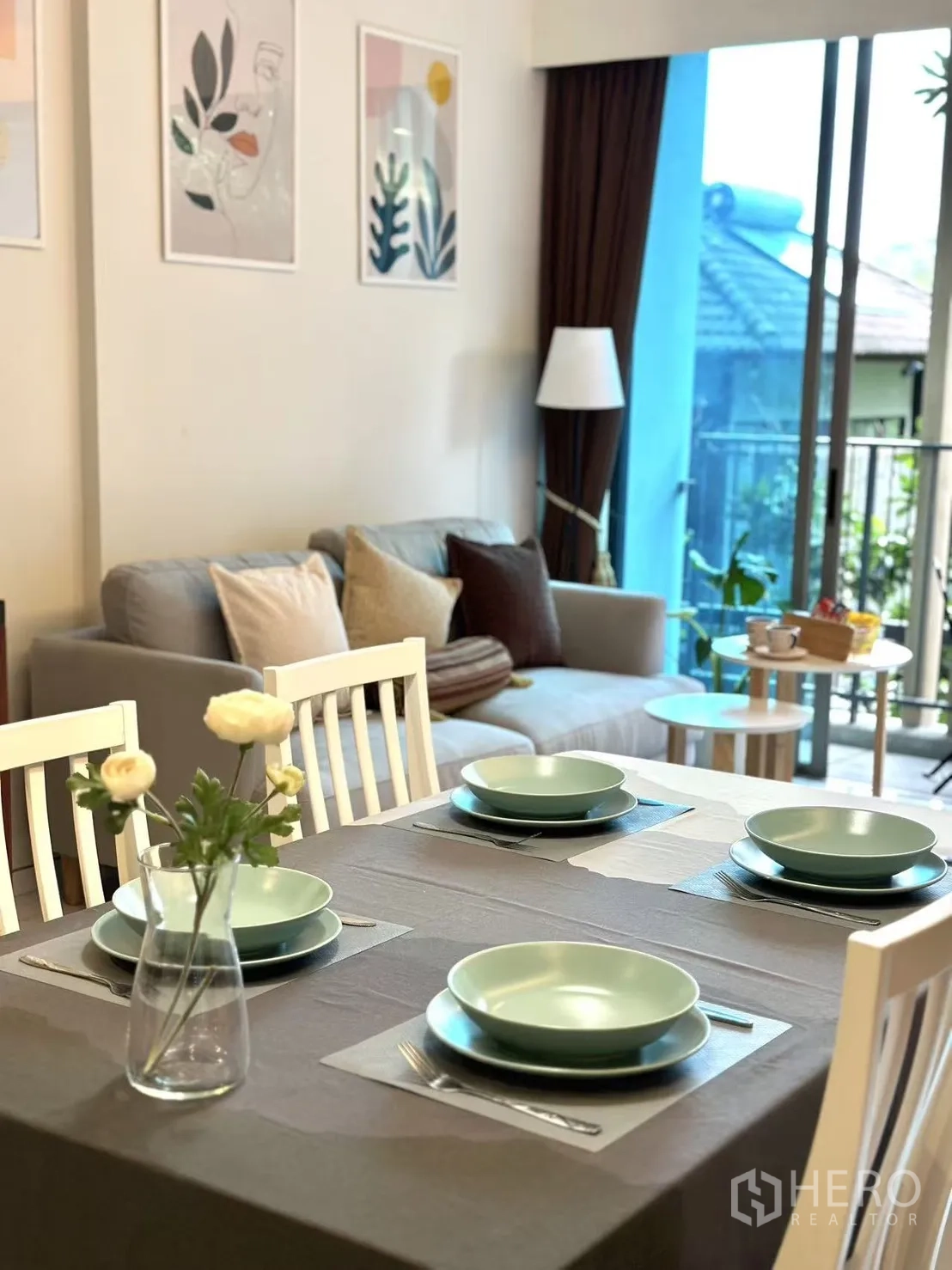 คอนโด ขายในWatthana, Bangkok - ภาพระยะใกล้โต๊ะอาหารสี่ที่นั่ง เห็นโซฟาและระเบียงด้านหลัง