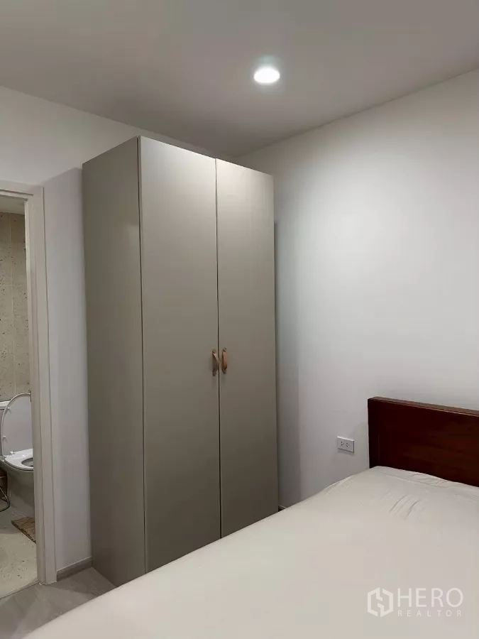 Townhouse for rent in Saphan Sung, Bangkok - Bedroom corner with free-standing wardrobe and entrance to an ensuite bathroom.