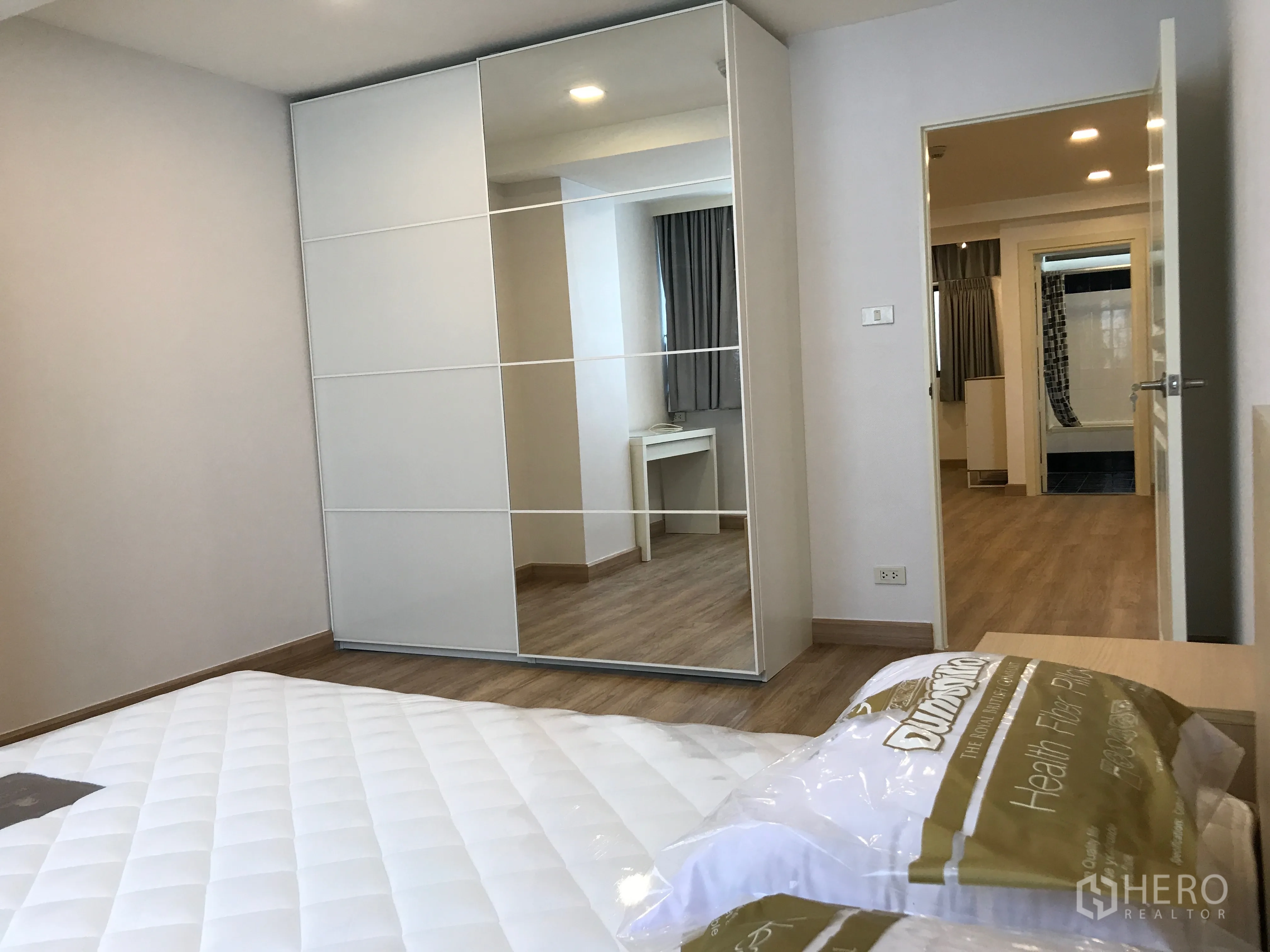 公寓 出售在Watthana, Bangkok - 卧室配镜面衣柜与梳妆台，木地板