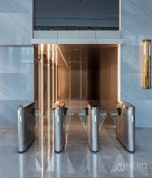 Office Space for rent in Sathon, Bangkok - Secure access turnstiles leading to a sleek elevator lobby with polished stone walls.