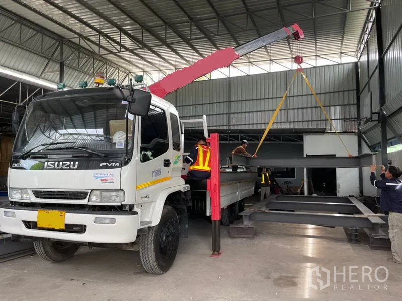 货栈 出租或出售在Khlong Luang, Pathum Thani - 有顶装卸区，起重卡车在仓内吊运钢梁，层高充裕。