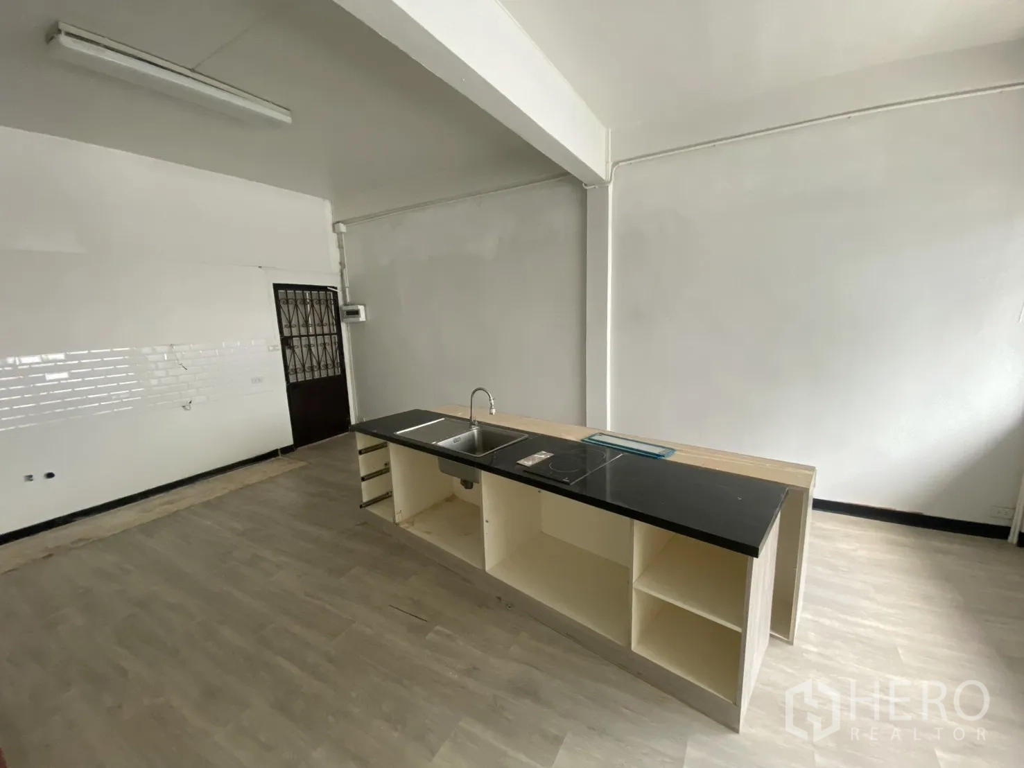 Shophouse for rent in Bang Rak, Bangkok - Pantry area with long island counter, sink, and cooktop in a spacious room.