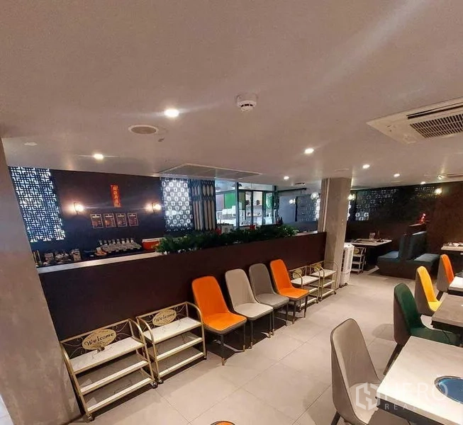 零售空间 出租在Watthana, Bangkok - 室内座位区，彩色椅子、吧台和花纹隔断。