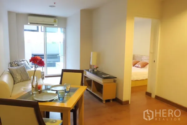 คอนโด ขายในPhra Khanong, Bangkok - ห้องนั่งเล่นแบบโอเพ่นเชื่อมระเบียงผ่านประตูกระจกบานเลื่อน มองไปยังทางเข้าห้องนอน